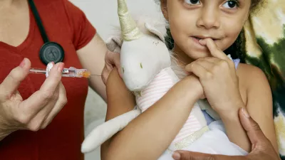 young girl receives vaccine