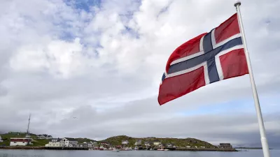 Norwegian flag raised over seaside village