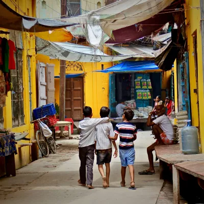 three boys walking down a street in India