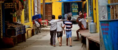 three boys walking down a street in India
