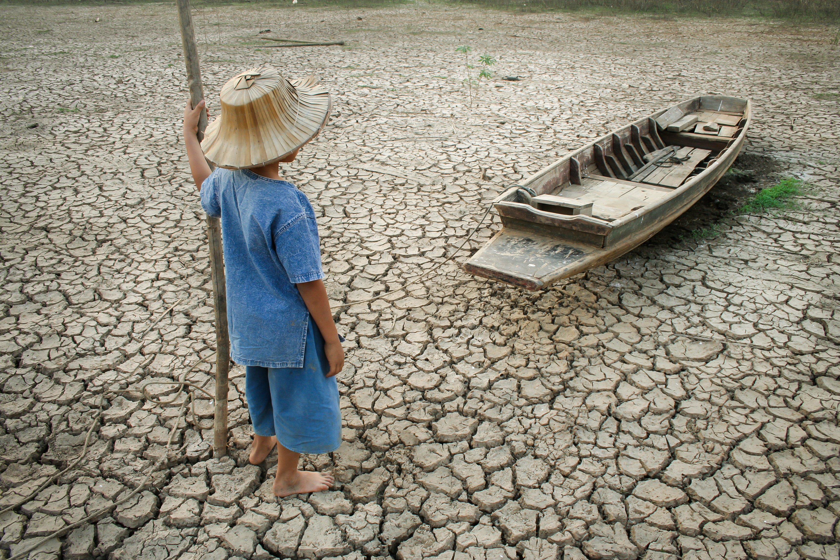 A child looks out over a dried up lake