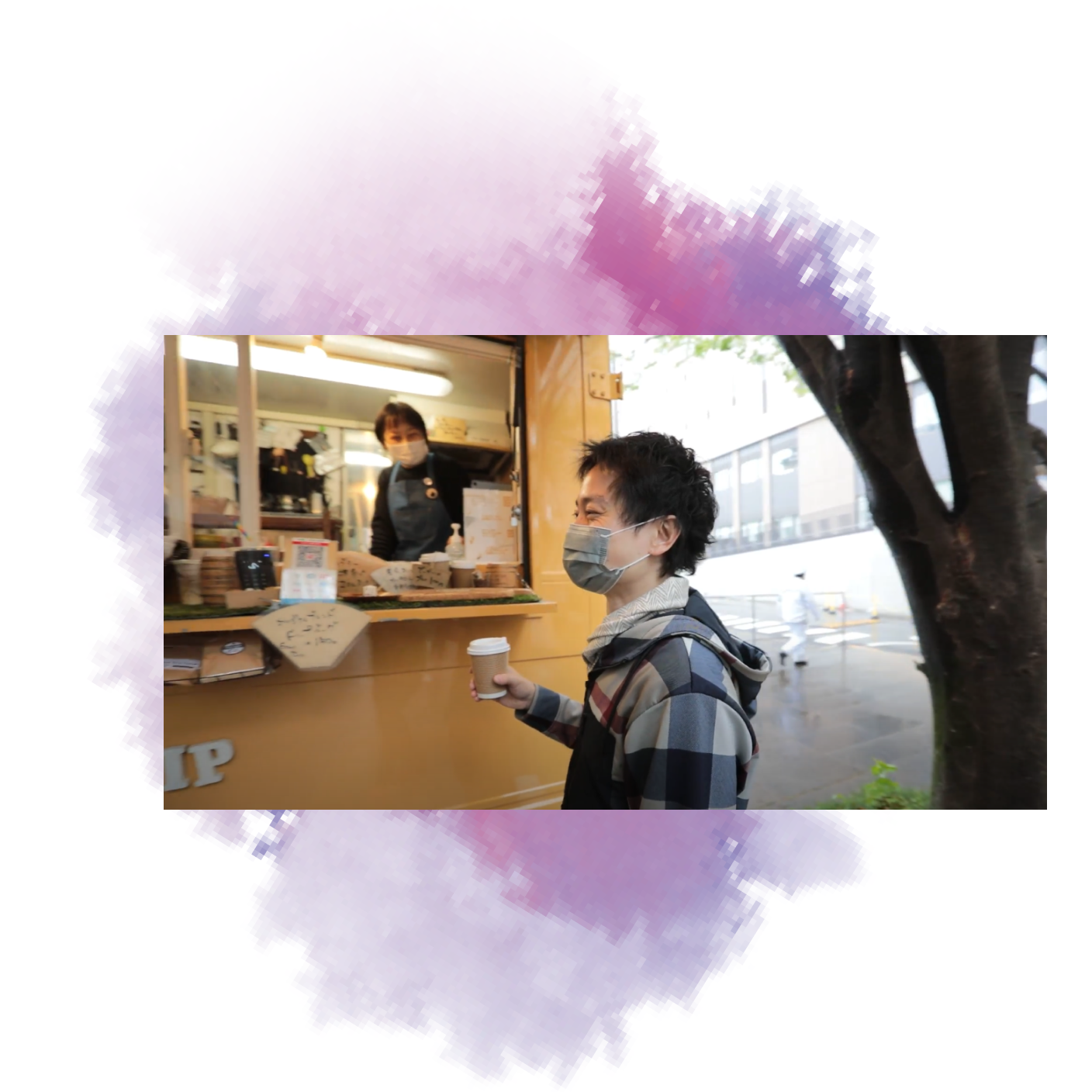 Dr. Nomura wears a mask while holding a cup of coffee outside a cafe kiosk