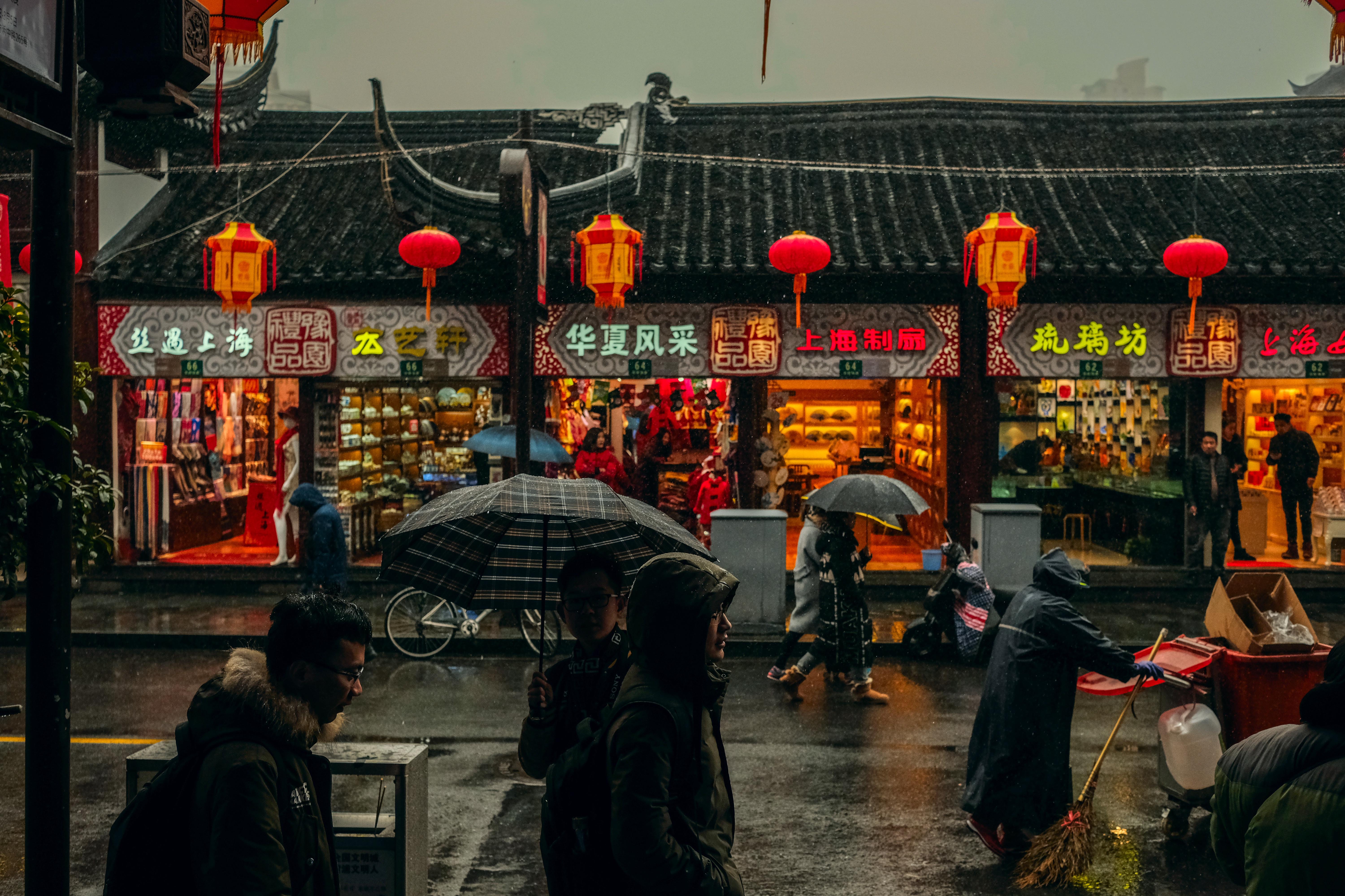 people walking down a street in Shanghai on a rainy day