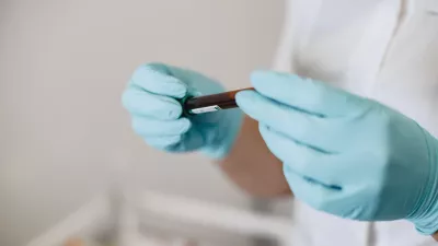 lab technician holds a vial of blood