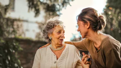 an elderly woman and her caregiver share a laugh 
