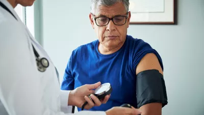 Doctor checking an older person’s blood pressure 