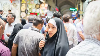 woman wearing headscarf navigates through a crowded market