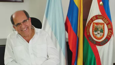 Dr. Rodrigo Guerrero sits in front of the Colombian flag