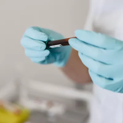 lab technician holds a vial of blood
