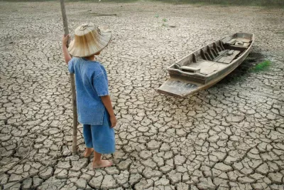 child stands on a dried out lake